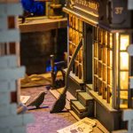 cozy-fairy-tale-reading-nook-for-shelves Cozy fantasy book nook kit positioned between books on a wooden bookshelf display