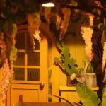 cozy-reading-corner-miniature-house-scene Cozy reading corner with miniature greenhouse house scene between books