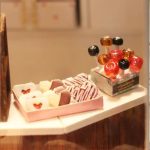detailed-miniature-cocoa-themed-dollhouse-scene Detailed miniature cocoa-themed dollhouse scene with warm LED glow
