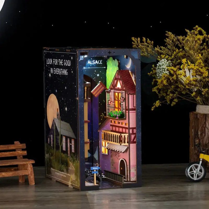 dreamland-of-alsace-book-nook-kit Dreamland of Alsace Book Nook Kit assembled on bookshelf with painted timber facades and cobblestone alley