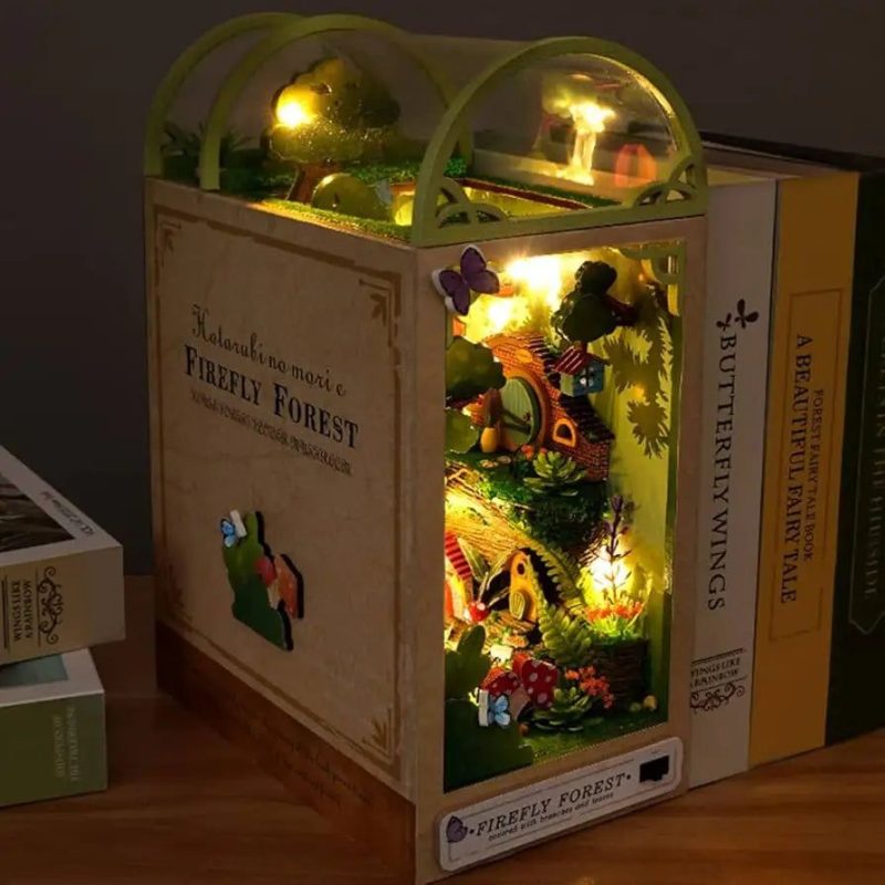 firefly-forest-book-nook-kit Firefly Forest Book Nook Kit with warm LED glow assembled between books on wooden shelf