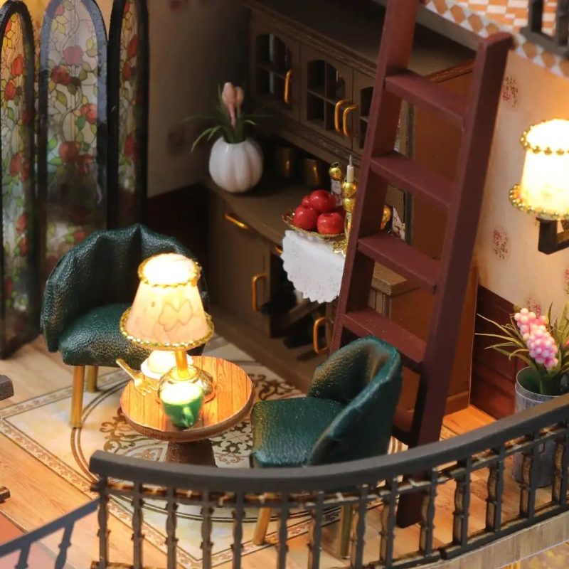 hobbyist-miniature-house-project-with-paint-and-glue Builder assembling cottage miniature house using included glue and wooden panels