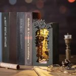 illuminated-book-nook-miniature-house-scene Illuminated fantasy book nook with warm amber LED glowing softly on a wooden bookshelf