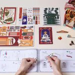 Illuminated Christmas village bookshelf insert with intricate miniature architectural details