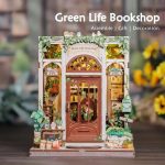miniature green bookshop diorama displayed between books on shelf