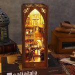 miniature-library-book-nook-diorama-for-bookshelf Miniature library book nook diorama inserted between books on a wooden bookshelf