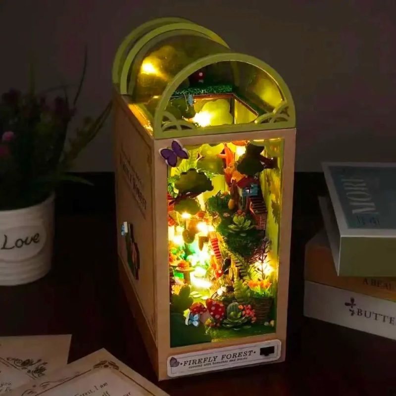 miniature-woodland-book-nook-with-warm-led-lights DIY miniature woodland book nook with warm LED string threading through forest canopy layers