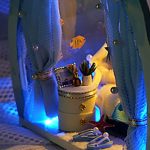 ocean-depth-inspired-dollhouse-micro-scene-kit Ocean depth-inspired teal miniature house kit with integrated warm LED module casting light across sea-cave interior