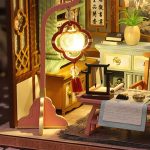 tiny-ink-wash-artwork-for-miniature-dollhouse-scenes Tiny ink-wash artwork panels inside miniature dollhouse study showing detailed brush-painting reproduction and negative space design