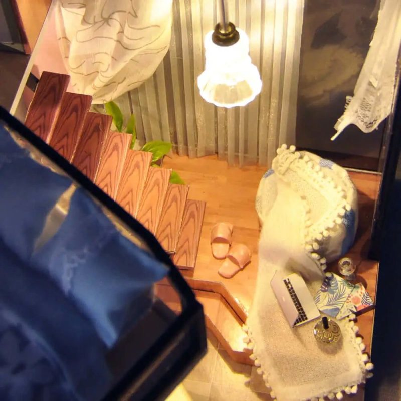 tiny-scale-model-house-with-led-lights Completed miniature house kit with warm LED string lights glowing inside