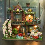Wooden fairy cottage miniature kit with LED lighting glowing at dusk